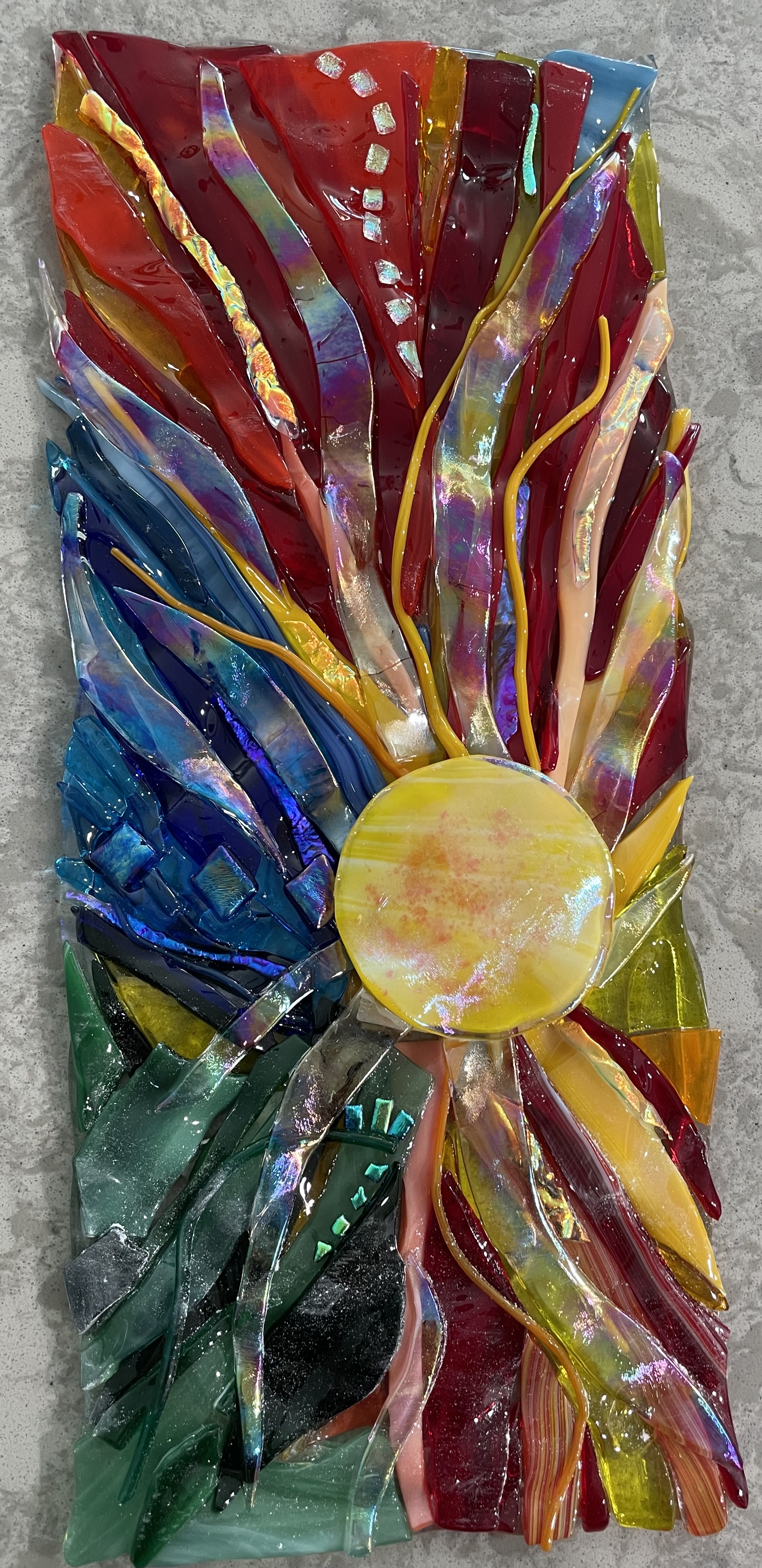 A vertical fused-glass panel suggesting a golden sunburst.
