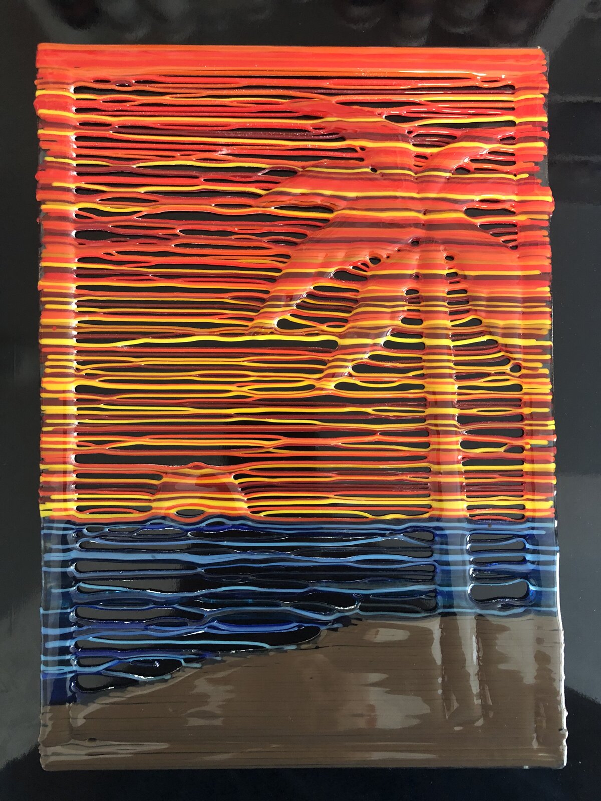 Vertical stringer panel of a tropical sunset: a palm tree silhouetted against orange and red lines, blue water and a sandy beach below, in a black border.