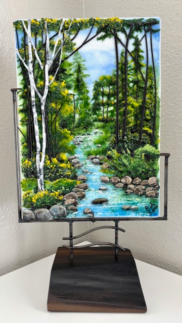 Forest Serenity: a vertical fused-glass panel of birch trunks against a misty green forest, mounted on a sculptural metal stand.