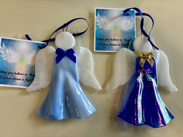 Angel: fused-glass angel ornaments with white glass wings, one in pale blue and one in iridescent cobalt.
